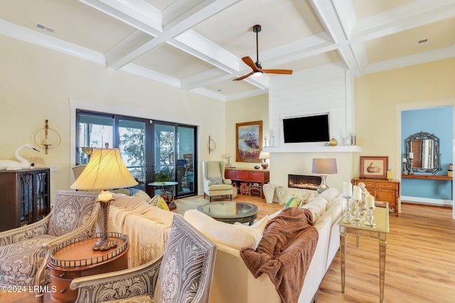 living room with light hardwood / wood-style flooring, coffered ceiling, a fireplace, french doors, and beamed ceiling