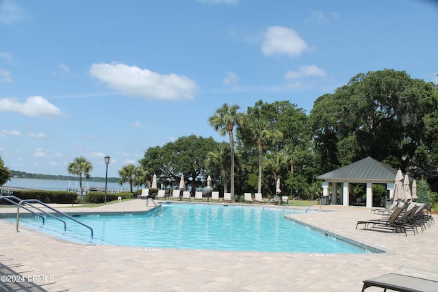 view of swimming pool with a gazebo, a water view, and a patio