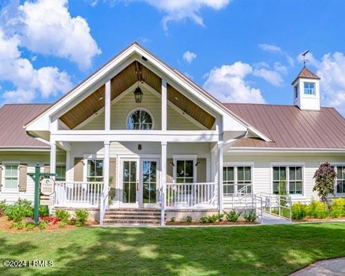 rear view of property featuring a lawn and a porch