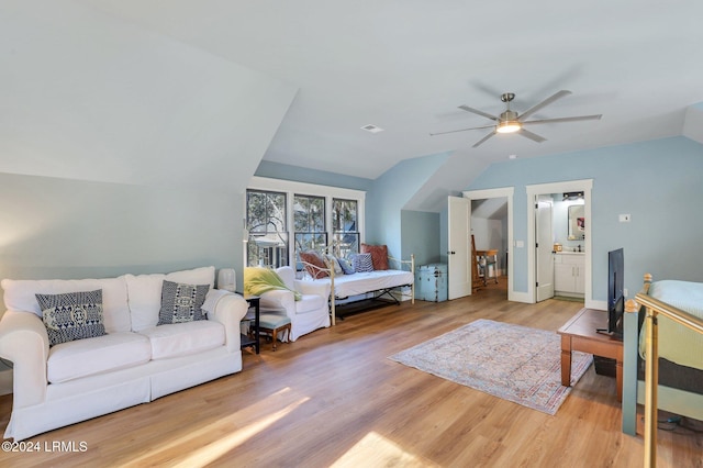 bedroom with vaulted ceiling, connected bathroom, hardwood / wood-style floors, and ceiling fan