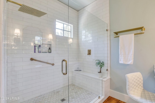 bathroom with a shower with shower door and wood-type flooring