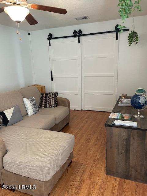 24 Walter Dr, Beaufort, SC 29906 - living room featuring a barn door, wood finished floors, and ceiling fan