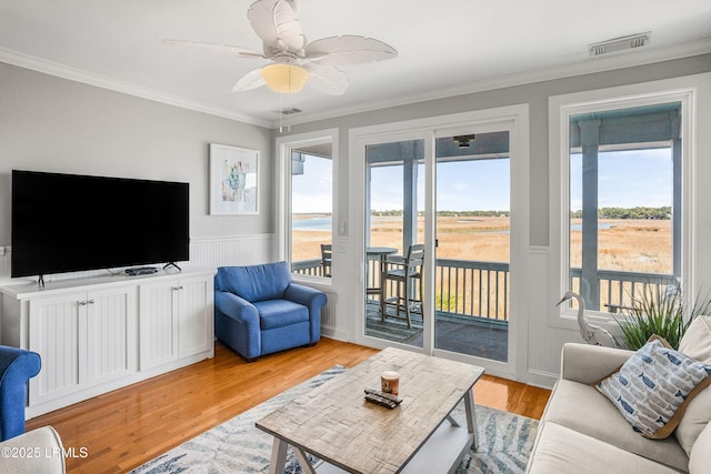 living room with crown molding, ceiling fan, and light hardwood / wood-style floors