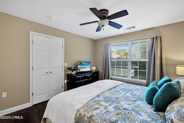 bedroom with dark wood-type flooring, ceiling fan, and a closet