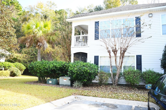 view of front facade with a front lawn and a balcony