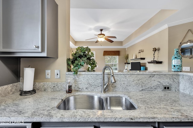 kitchen featuring sink, ornamental molding, ceiling fan, and light stone countertops