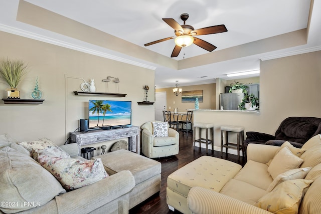 living room featuring dark hardwood / wood-style flooring, a raised ceiling, and ceiling fan with notable chandelier