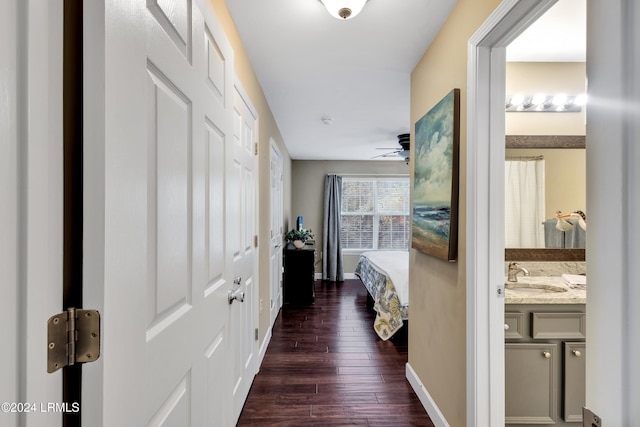 corridor featuring dark wood-type flooring and sink