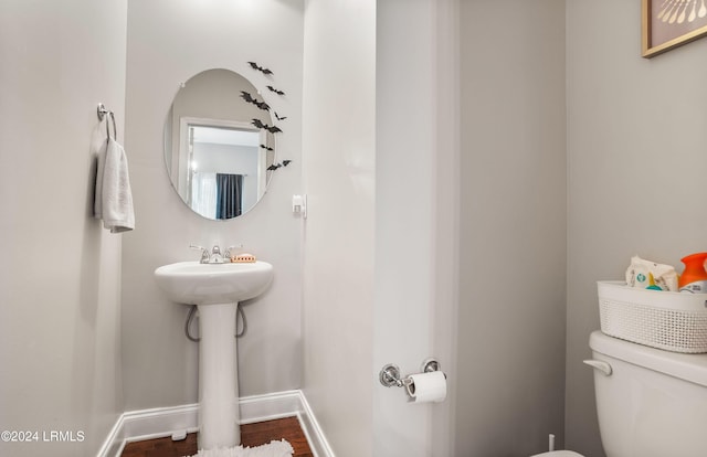 bathroom featuring wood-type flooring and toilet