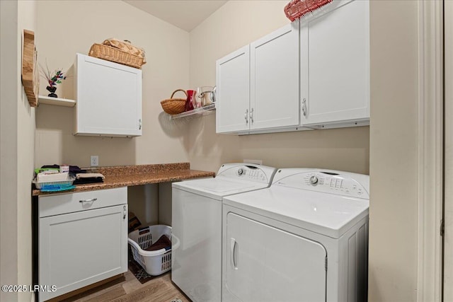 clothes washing area featuring independent washer and dryer, light hardwood / wood-style flooring, and cabinets