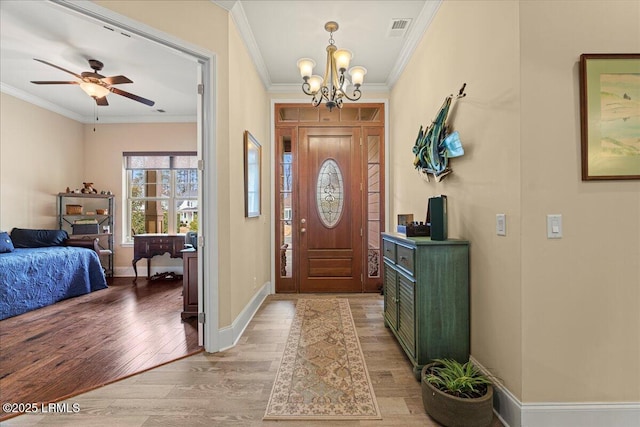 foyer with ornamental molding, ceiling fan with notable chandelier, and light hardwood / wood-style floors