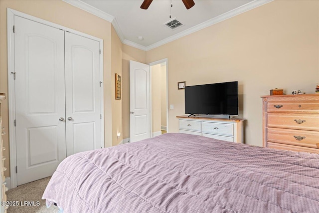 carpeted bedroom with crown molding, ceiling fan, and a closet