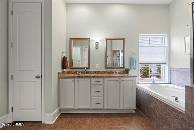 bathroom featuring vanity, tiled bath, and tile patterned flooring