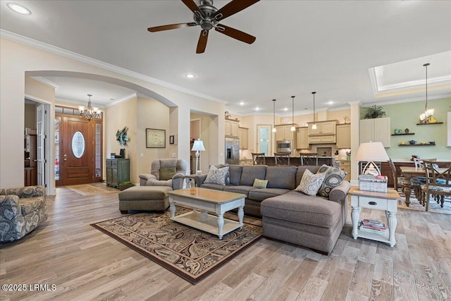 living room featuring light hardwood / wood-style flooring, ornamental molding, and a chandelier