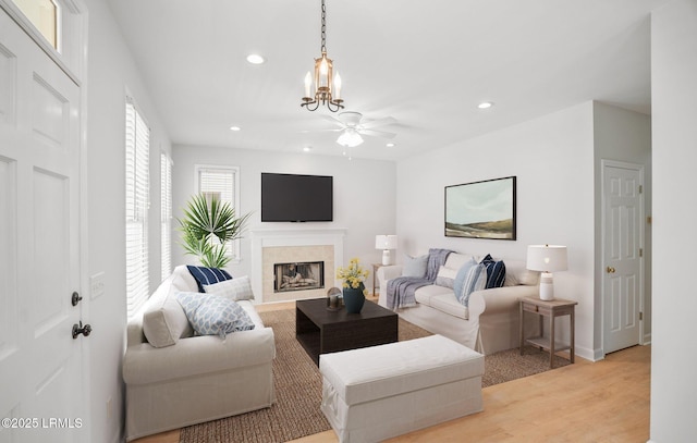 living room featuring recessed lighting, a fireplace, light wood-style floors, and ceiling fan