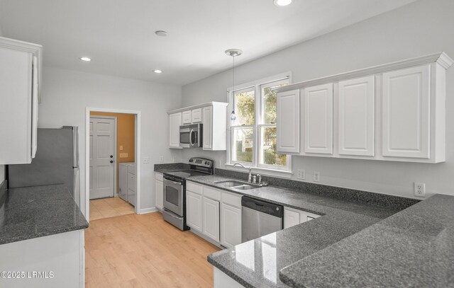 kitchen featuring a sink, recessed lighting, appliances with stainless steel finishes, white cabinets, and washing machine and clothes dryer