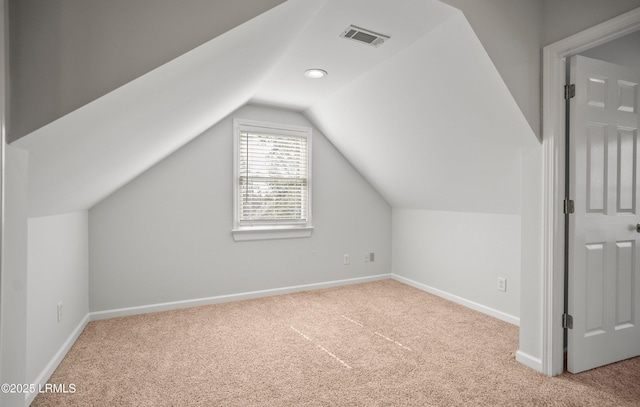 additional living space with vaulted ceiling, baseboards, visible vents, and carpet floors