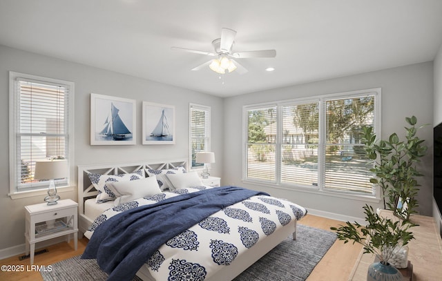 bedroom with visible vents, baseboards, and wood finished floors