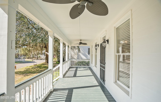 wooden deck featuring covered porch and ceiling fan