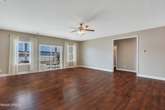 empty room with dark wood-type flooring, baseboards, and a ceiling fan
