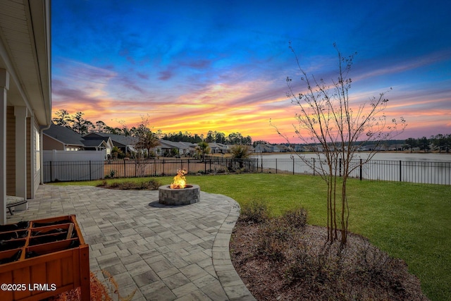 view of patio featuring a water view, a fire pit, and a fenced backyard