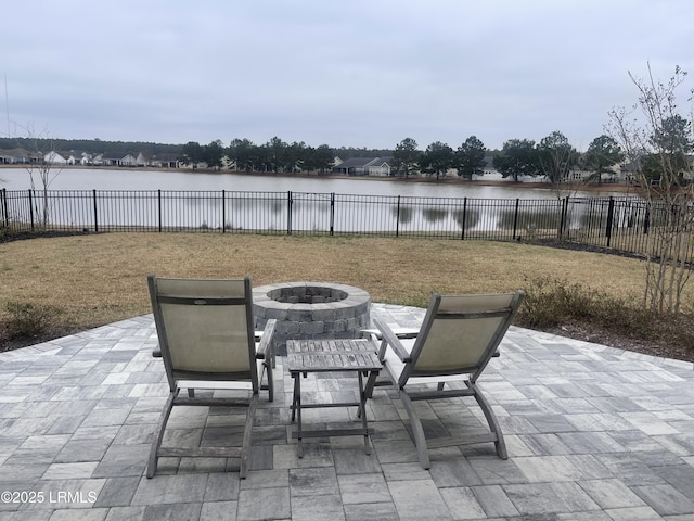 view of patio / terrace with a water view, an outdoor fire pit, and a fenced backyard