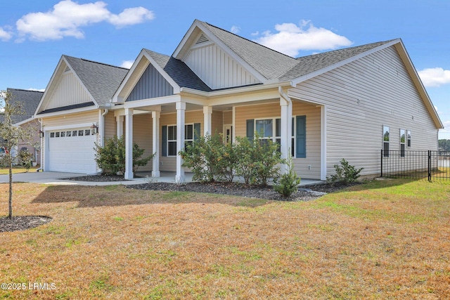 view of front of home with a porch, an attached garage, fence, a front lawn, and board and batten siding