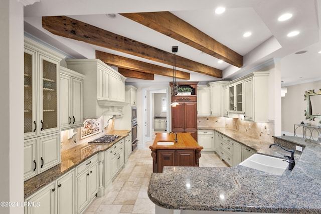 kitchen featuring pendant lighting, sink, dark stone countertops, kitchen peninsula, and beam ceiling