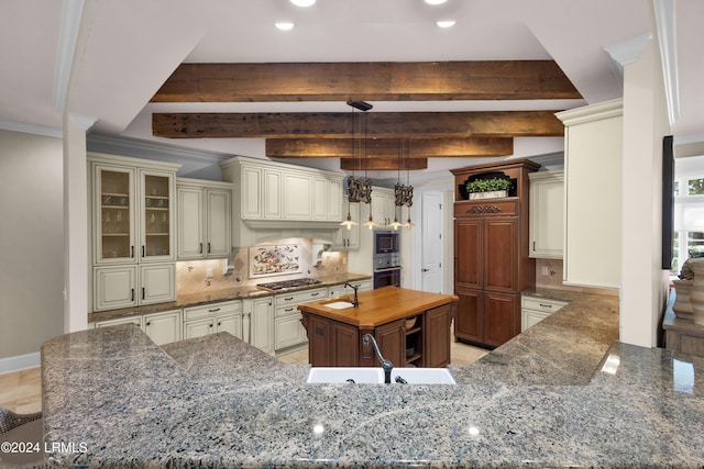 kitchen with butcher block countertops, beam ceiling, cream cabinets, a kitchen island, and decorative backsplash