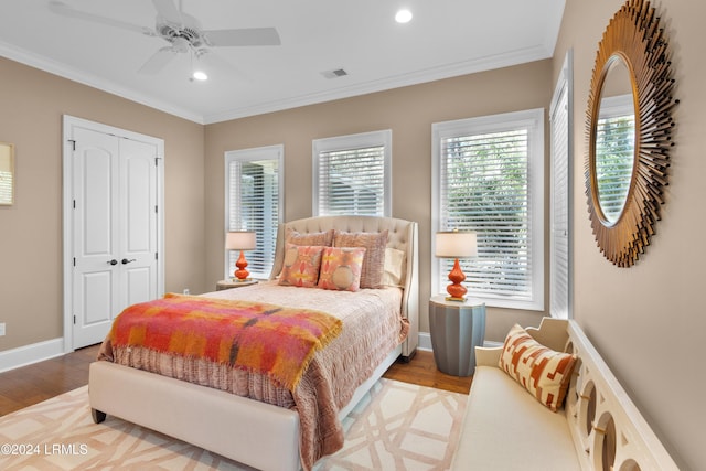 bedroom featuring ornamental molding, a closet, ceiling fan, and light wood-type flooring