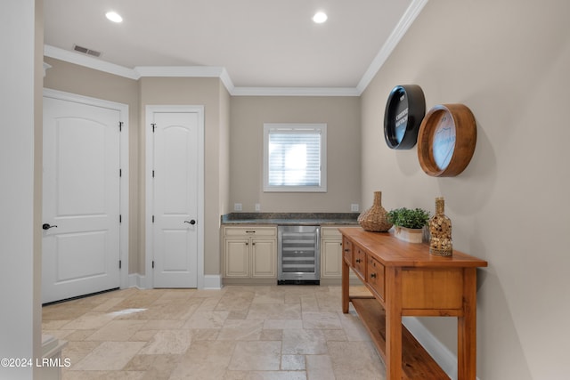 bar with dark stone countertops, crown molding, and beverage cooler