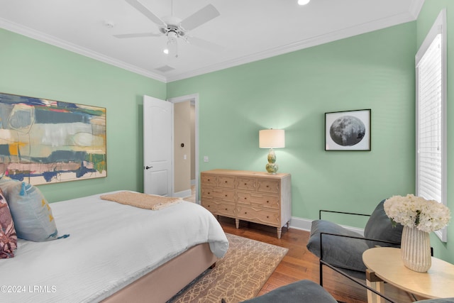 bedroom featuring hardwood / wood-style flooring, ornamental molding, and ceiling fan