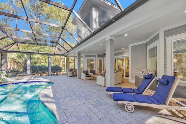 exterior space featuring outdoor lounge area, a patio, ceiling fan, and glass enclosure