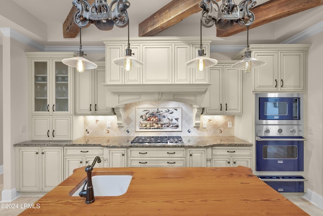 kitchen featuring tasteful backsplash, light stone countertops, decorative light fixtures, and stainless steel appliances