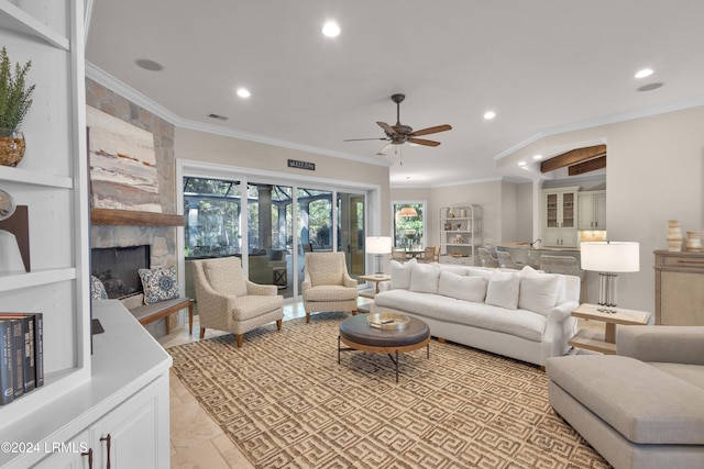 living room with ornamental molding, ceiling fan, and a fireplace