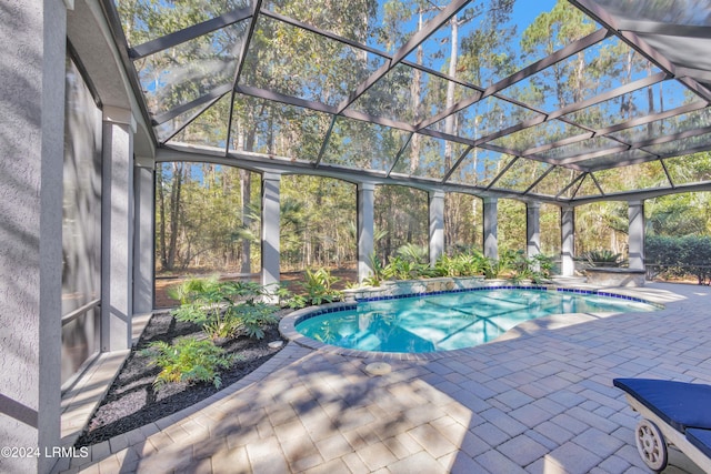 view of swimming pool featuring a lanai and a patio