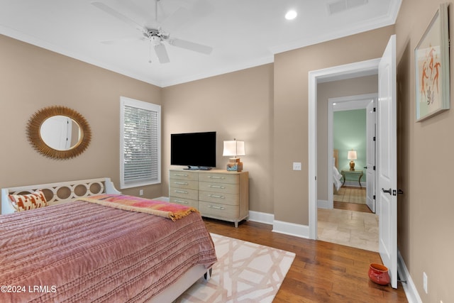 bedroom featuring crown molding, ceiling fan, and wood-type flooring