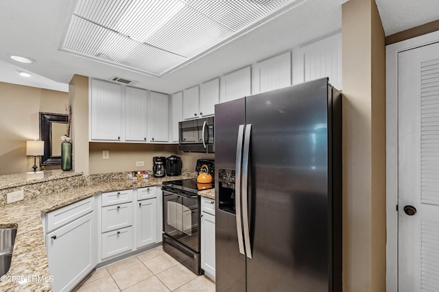 13 Harbourside Ln Unit 7170, Hilton Head Island, SC 29928 - kitchen featuring stainless steel fridge with ice dispenser, black electric range oven, light tile patterned floors, white cabinets, and light stone counters