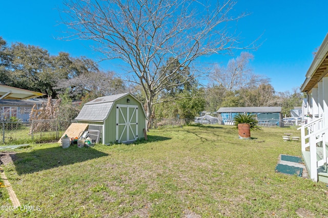 view of yard featuring a storage unit, a fenced backyard, and an outdoor structure