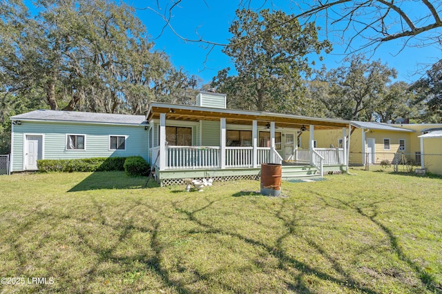 view of front of property with a front lawn, fence, covered porch, and a chimney