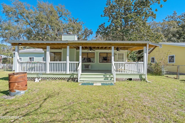 view of front of property featuring a front lawn, fence, a chimney, and ceiling fan