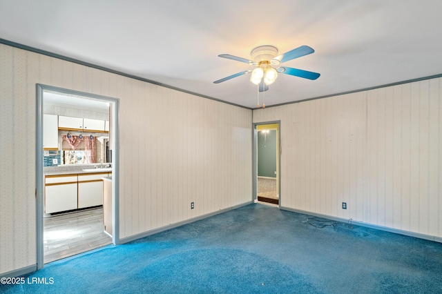 unfurnished room featuring ceiling fan, carpet floors, and a sink