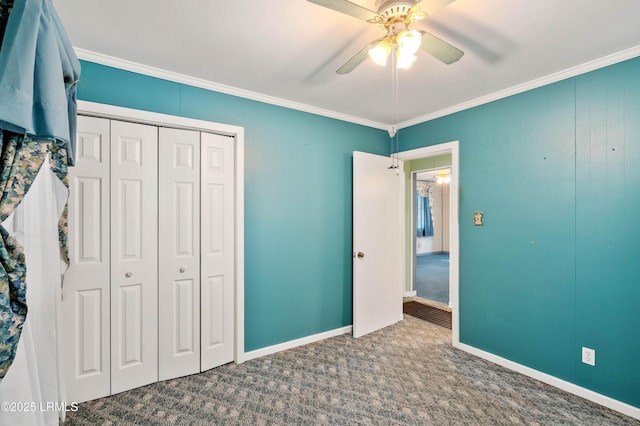 unfurnished bedroom featuring a closet, baseboards, carpet flooring, and crown molding