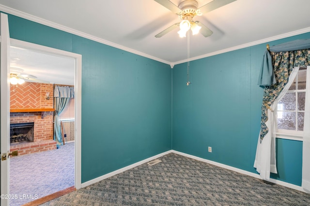 unfurnished room featuring baseboards, ornamental molding, carpet flooring, a fireplace, and a ceiling fan