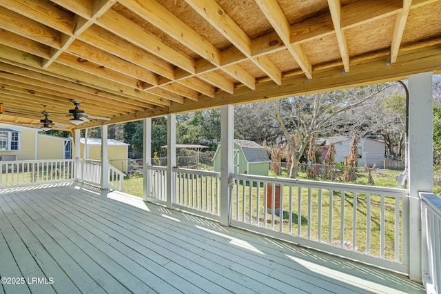 deck with an outbuilding, a fenced backyard, and a shed