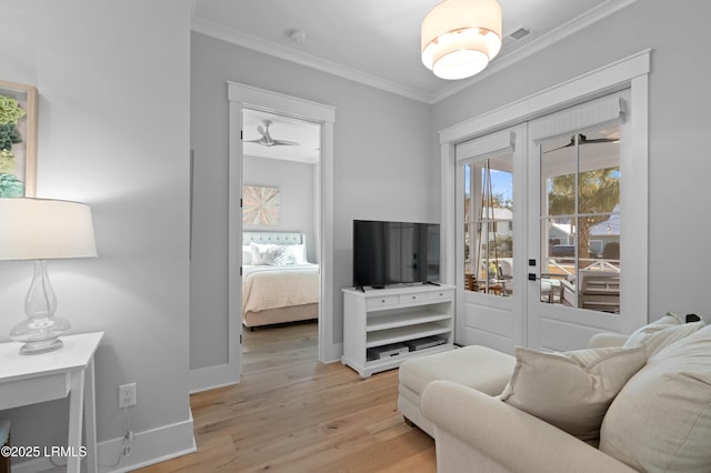 living room with crown molding, light hardwood / wood-style floors, and french doors