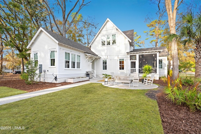 back of house with a sunroom, a yard, and a patio area