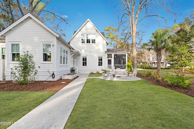 back of property featuring a sunroom, a yard, and a patio area