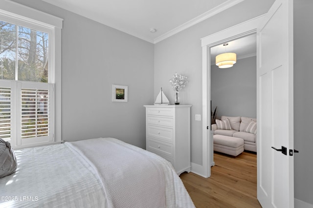 bedroom featuring crown molding and light hardwood / wood-style floors