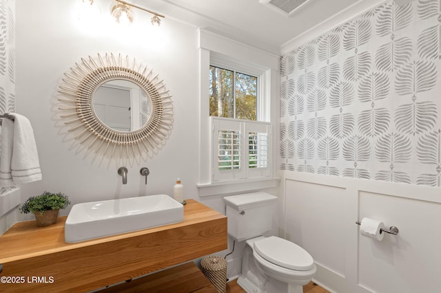 bathroom featuring crown molding, vanity, and toilet